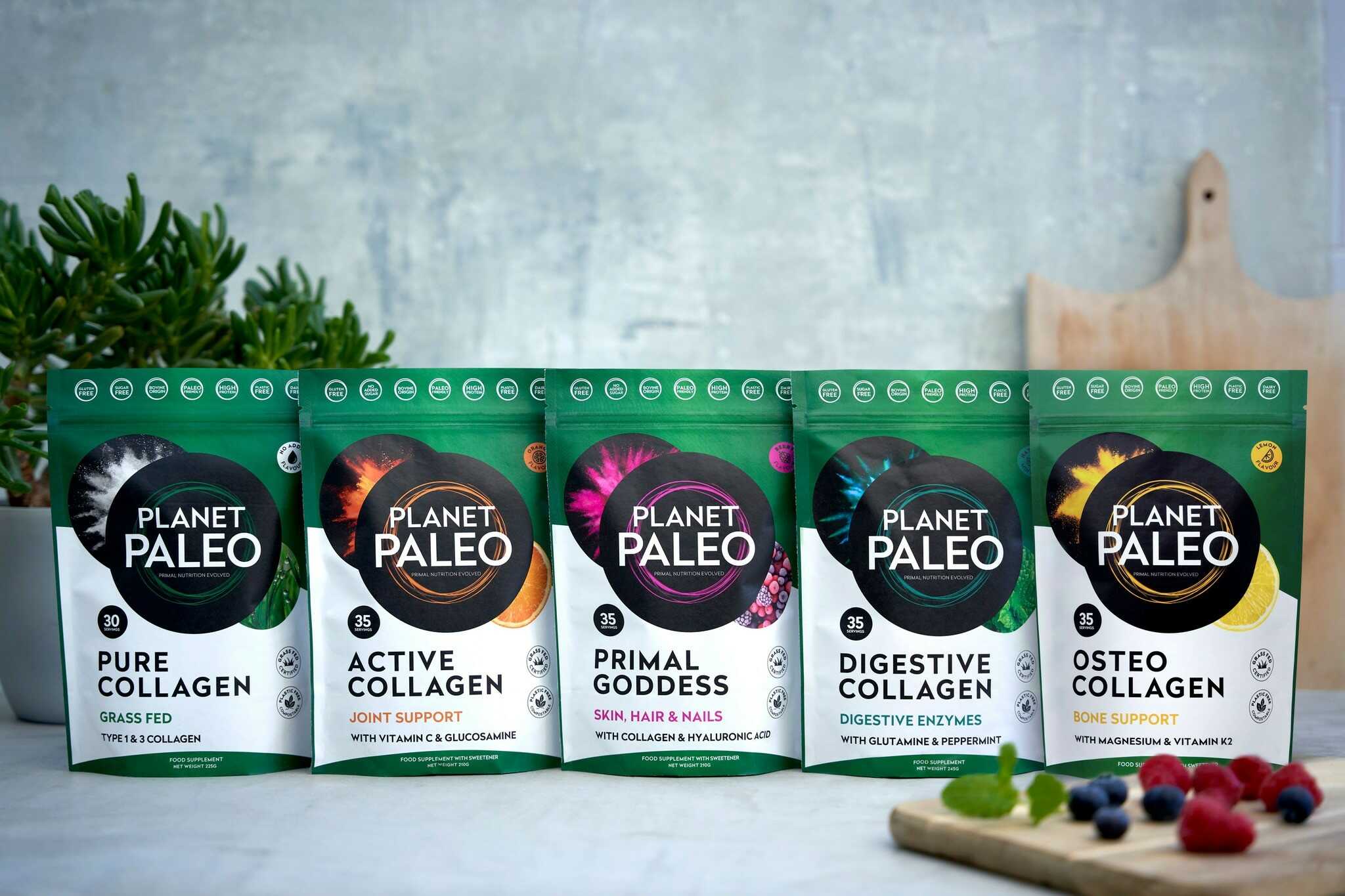 Planet Paleo collagen range – five stand-up pouches (Pure, Active, Primal Goddess, Digestive and Osteo Collagen) lined up on a kitchen counter with plants and berries.
